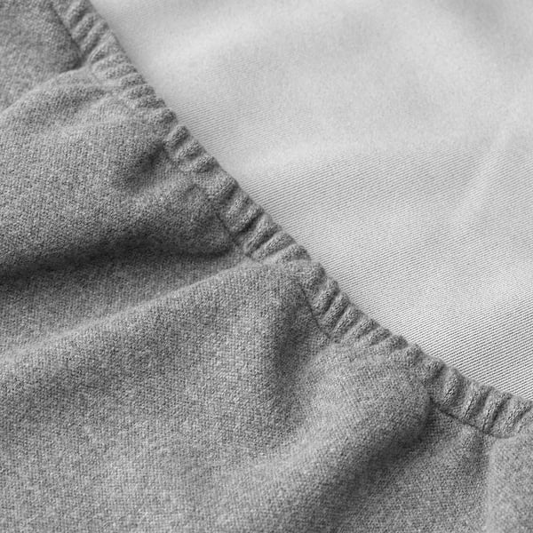 Close-up of soft, grey fabric, possibly a chair cover, with visible stitching detail.