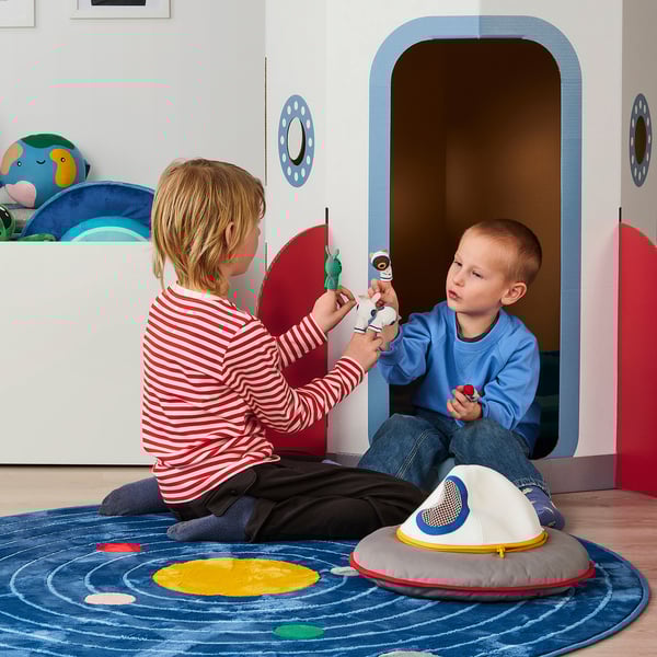 Children playing with finger puppets in front of a colourful playhouse.