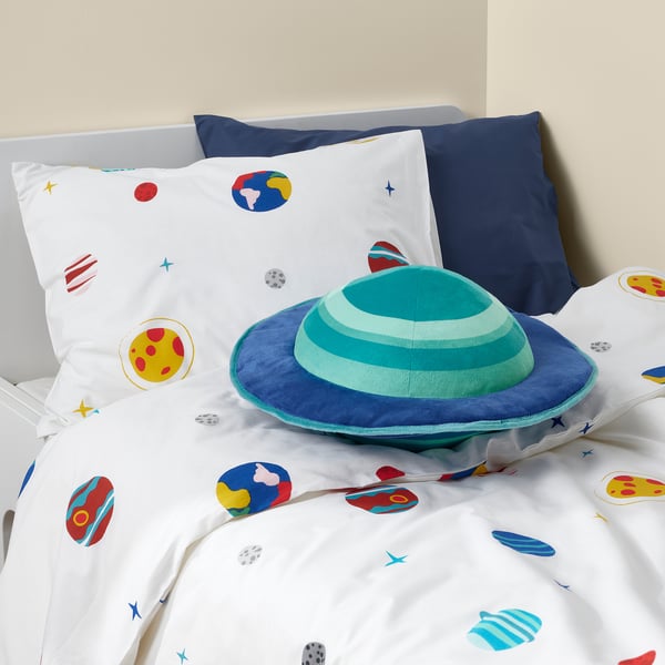 Childs bed with planet bedding, blue pillows, and ufo-shaped pillow.