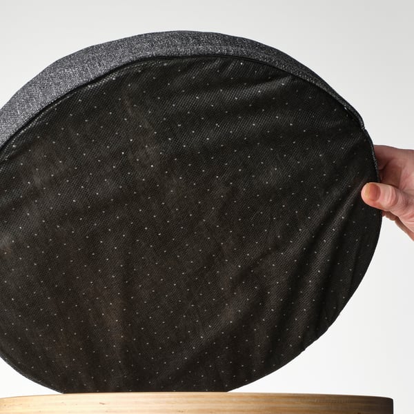 Grey memory foam chair pad held up, showing non-slip backing.