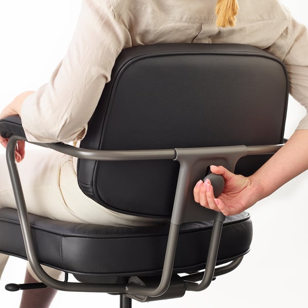 A person adjusts lumbar support on an ergonomic office chair.