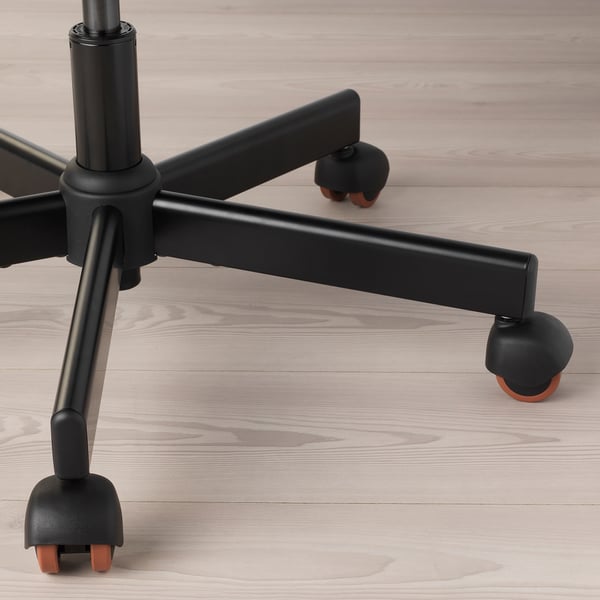 Black office chair base with smooth wheels on light wooden floor.