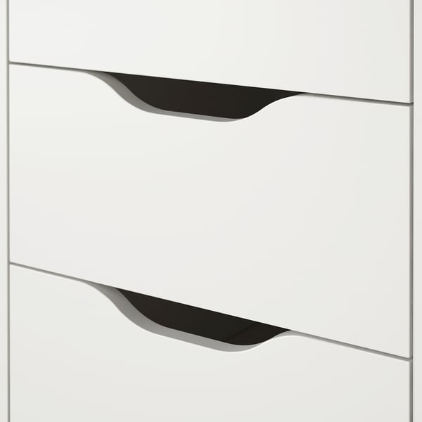 White drawer unit with sleek, black cut-out handles and smooth drawers, reflecting quality craftsmanship and modern design.