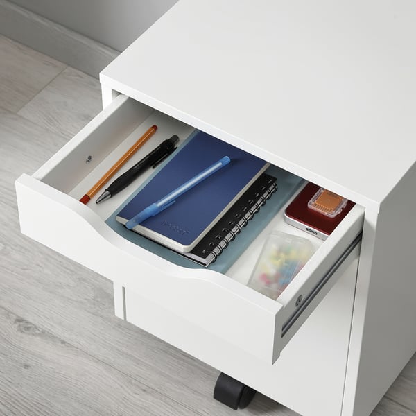 Open white ALEX drawer unit filled with stationery items like notebooks, pens, and pencils, designed for efficient workspace organisation.