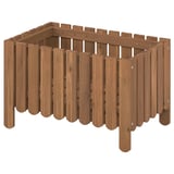 A wooden planter named ASKHOLMEN, made of acacia, with a natural brown stain. It has peg slats and stands on four legs.