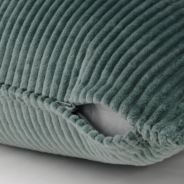Green corduroy cushion with zip closure, adding texture and style.