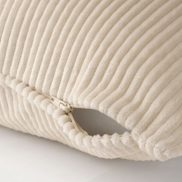 Close-up of cream-colored corduroy cushion with), zip open, showcasing hidden zip.