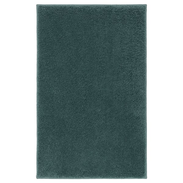 A green BACKMÅRA bath mat, rectangular, soft, and plush, designed for comfort and safety with latex backing.