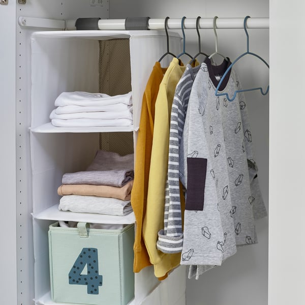 Closet with kids clothes organised on hangers and shelves.