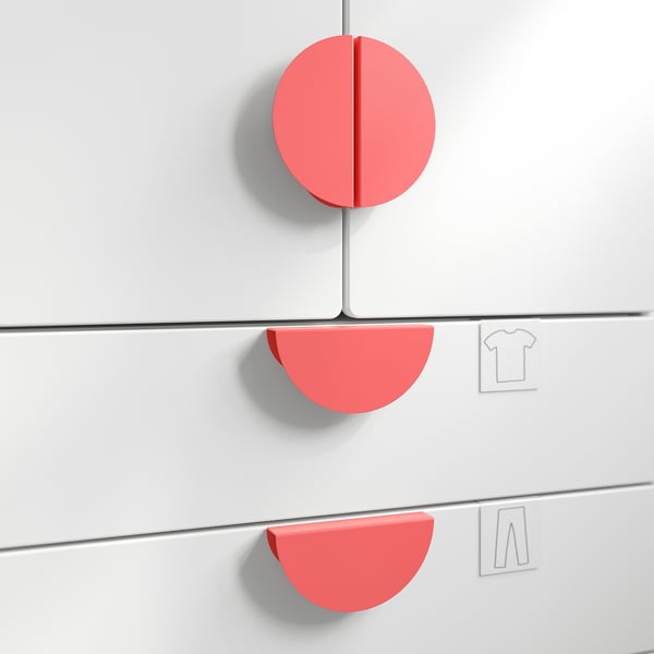 Red circular wall knobs, likely handles for storage, mounted on white wall.