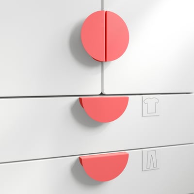 Red circular wall knobs, likely handles for storage, mounted on white wall.