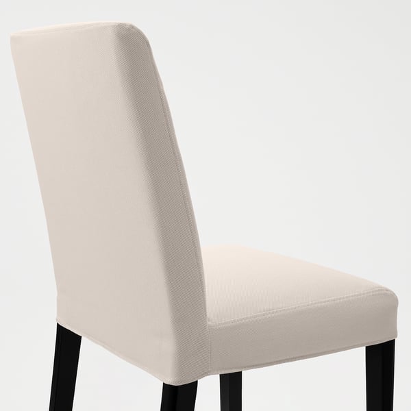 Stylish dining chair with sleek, beige upholstery and sturdy black legs for comfort and support.
