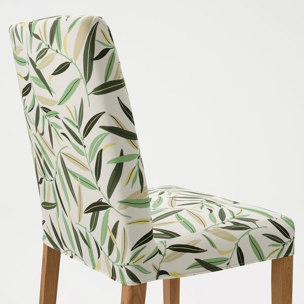 Stylish, ergonomic chair with leafy-patterned cover, wooden legs, and supportive design.