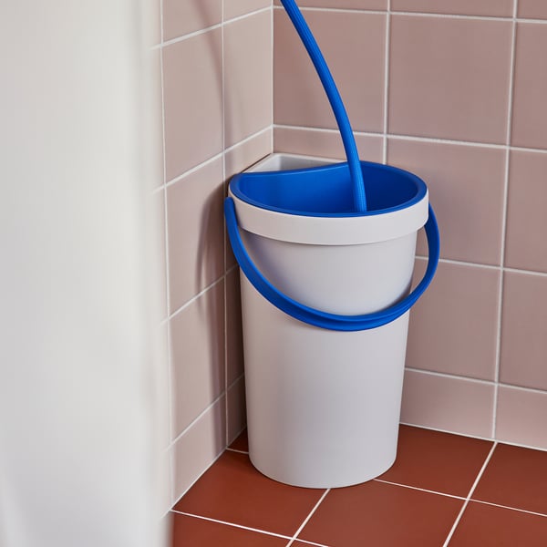 Blue-hued shower bucket with handle collecting excess water.