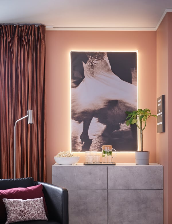 Modern living room with BESTÅ concrete sideboard, large wall art, potted plant, snacks, and dark curtains.