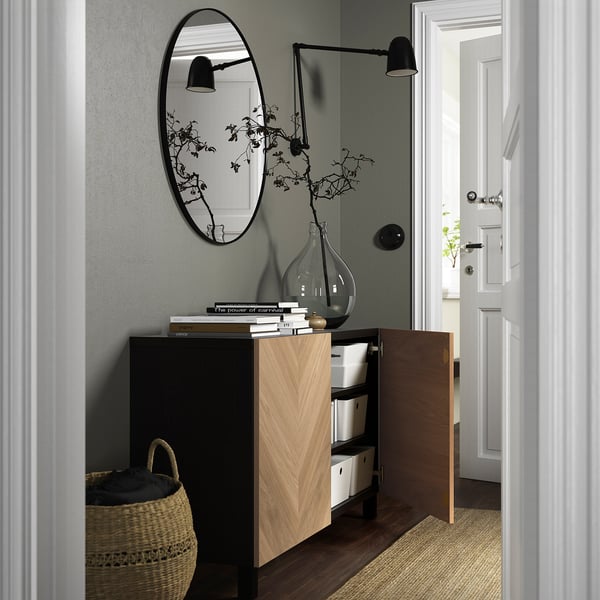 Modern entryway with cabinet, books, vase, mirror, lights