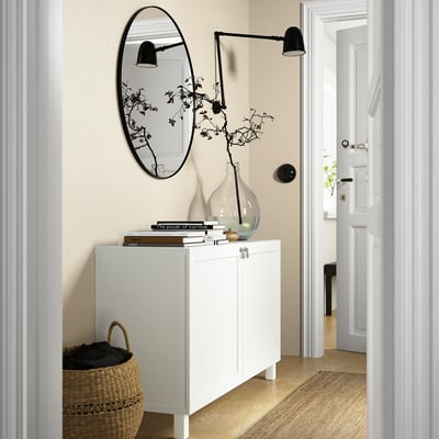 Modern entryway with BESTÅ sideboard, mirror, light, and vase.