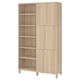 Ikea BESTÅ light oak storage unit: six adjustable shelves split into open and closed sections, standing on sturdy wooden legs.