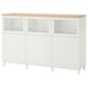White BESTÅ cabinet with glass doors, adjustable shelves, wooden top, and angled legs.