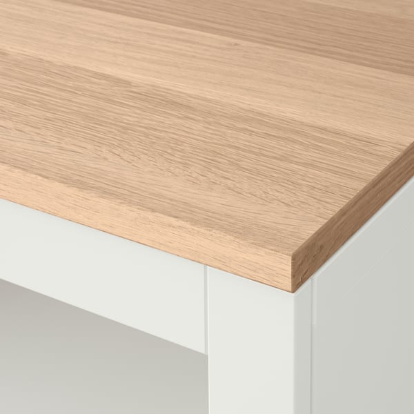 A close-up of a white and wooden table top, showcasing the smooth finish and fine grain of oak veneer.