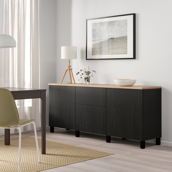 Modern living room with BESTÅ sideboard, plant, lamp, art, green chair.