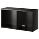 An ikea BESTÅ black tv stand with an open compartment. Its made of particleboard and has a minimalist rectangular design.