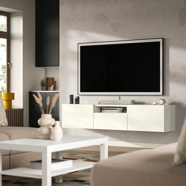 White BESTÅ tv bench with drawers, flat-screen tv and minimalist decor.