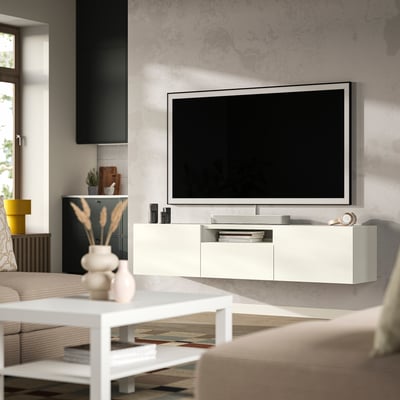 White BESTÅ tv bench with drawers, flat-screen tv and minimalist decor.
