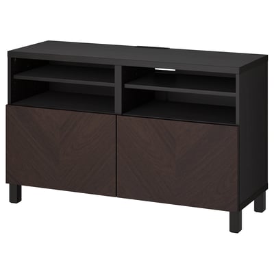 Black-brown ikea BESTÅ tv bench with chevron doors and shelves.