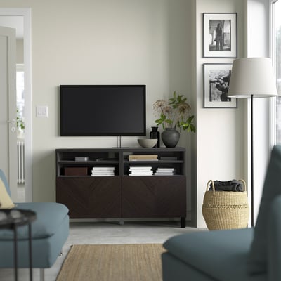 Modern living room with BESTÅ tv bench, blue sofa, & framed photos.