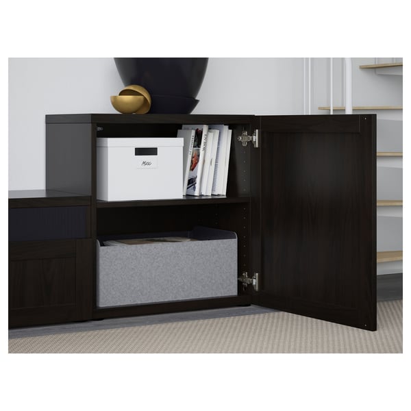 Black wooden cabinet with open door revealing storage boxes and shelves.