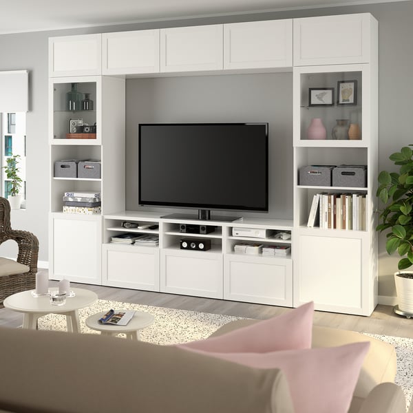 Modern living room with large BESTÅ white tv unit, flat screen, and decorations. Couch and coffee table nearby.