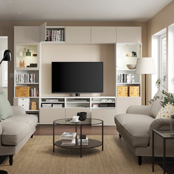 Modern living room with BESTÅ tv storage, shelves, & wall cabinets. Light furniture & dark coffee table.
