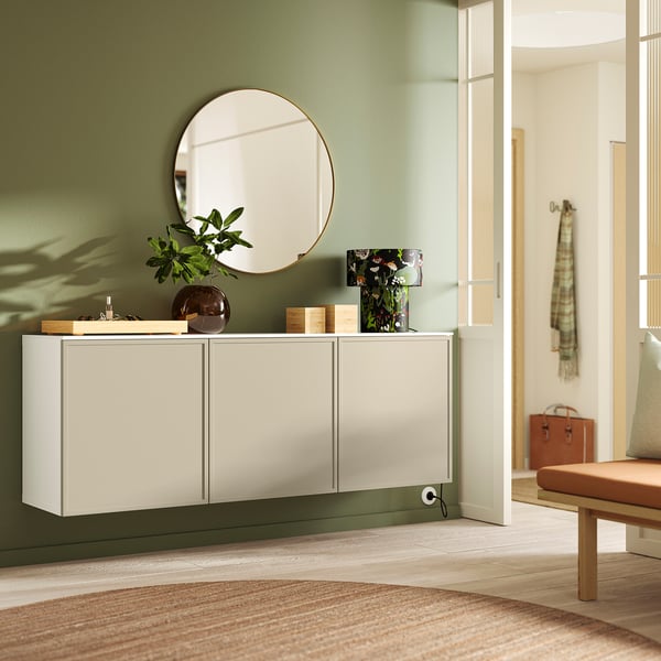 White BESTÅ sideboard with green accents, wall-mounted, three cabinets. Compliments green wall and decor.
