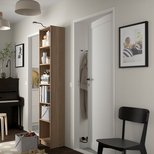 Modern hallway with BILLY bookcase, black chair, coat hooks, and baby photo.