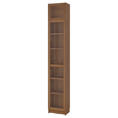A tall, wooden BILLY bookcase with five shelves and glass doors at the top. Its an elegant storage solution with a natural wood finish.