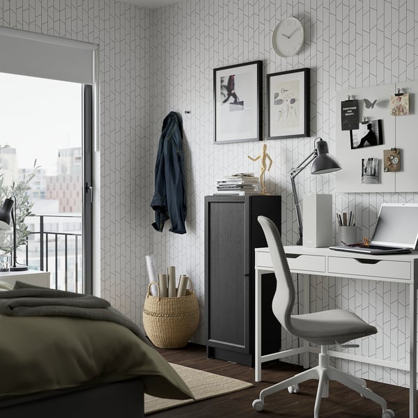 Modern study area with BILLY bookcase and swivel chair by a window.