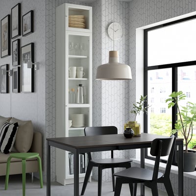 Modern living room with black dining set, green stool, BILLY bookcase, city view.