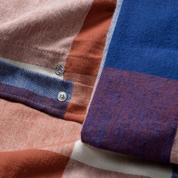 Close-up of warm, soft, chequered BLÅSENAP flannel blanket, showcasing its quality stitching and comfy fabric.