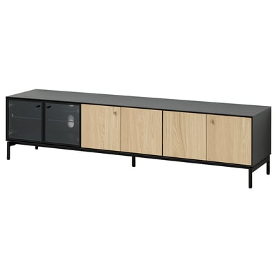 A sleek BOASTAD tv bench in black and light wood. It glass and wooden doors, thin lines, and adjustable feet.