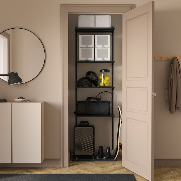 Black BOAXEL shelves in closet with boxes, sports gear, luggage, mirror, and coat rack.