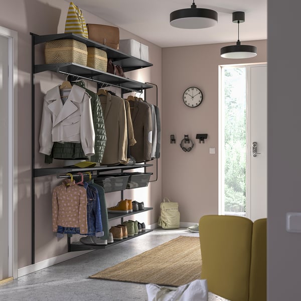 BOAXEL storage system in bedroom with clothes, baskets, clock, hooks, rug, chair.