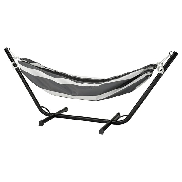 The BOCKÖN hammock, black & white striped, hangs on a metallic frame. Perfect for relaxing outdoors.