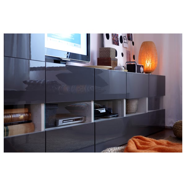 Modern living room with BÖJA tv unit, books & decor. Orange lamp adds warmth.
