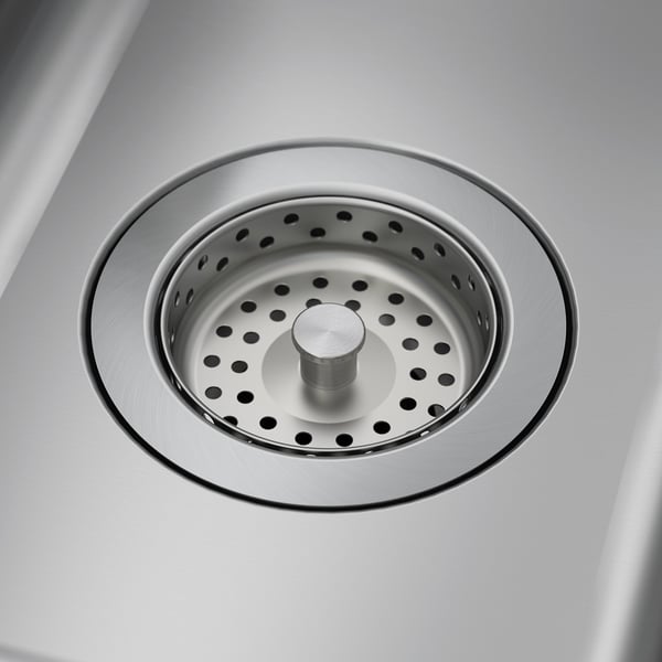 Stainless steel sink drain with central plug, polished to a shine, reflecting cleanliness and durable quality.
