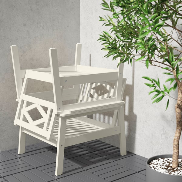 White outdoor furniture set includes a table and two stackable chairs with geometric designs, perfect for relaxing.