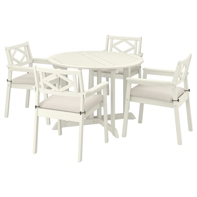The bondholm outdoor dining set a white round table and four matching chairs with armrests, providing a cosy and elegant outdoor seating arrangement.