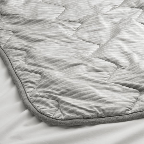 Detailed close-up of a neatly quilted grey duvet, showcasing its textured stripes and smooth finish, emphasising quality.
