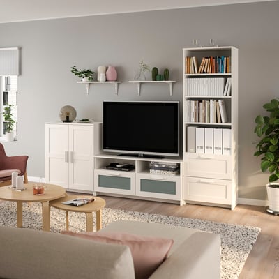 Bright living room with white BRIMNES storage set. Tv on stand, bookshelf, and cabinets. Light-filled, organised, and modern.