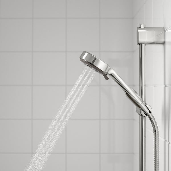 Showerhead spraying water, attached to metallic bar with hose. Chrome finish, offering full spray function.